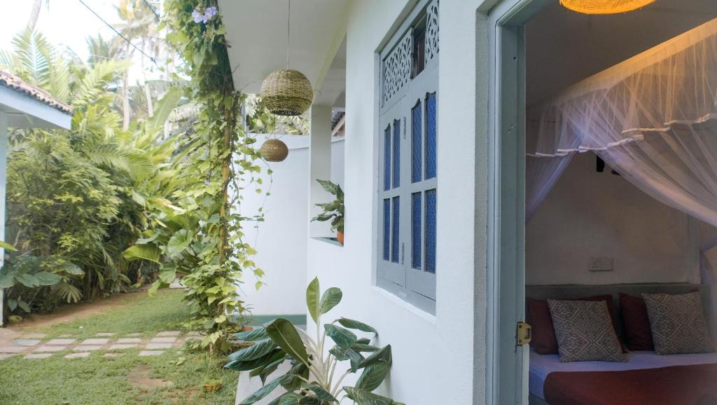 an open door of a house with a garden at Surf Lodge Madiha in Matara