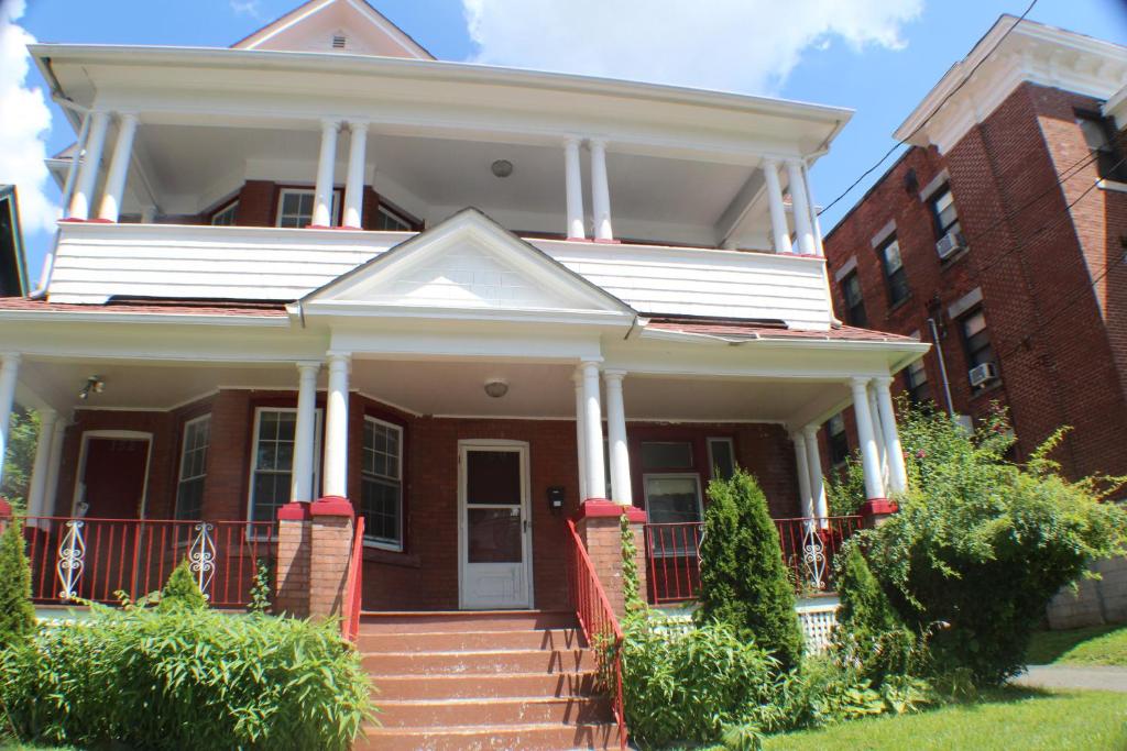 a red brick house with a porch and stairs at West End Haven in Hartford