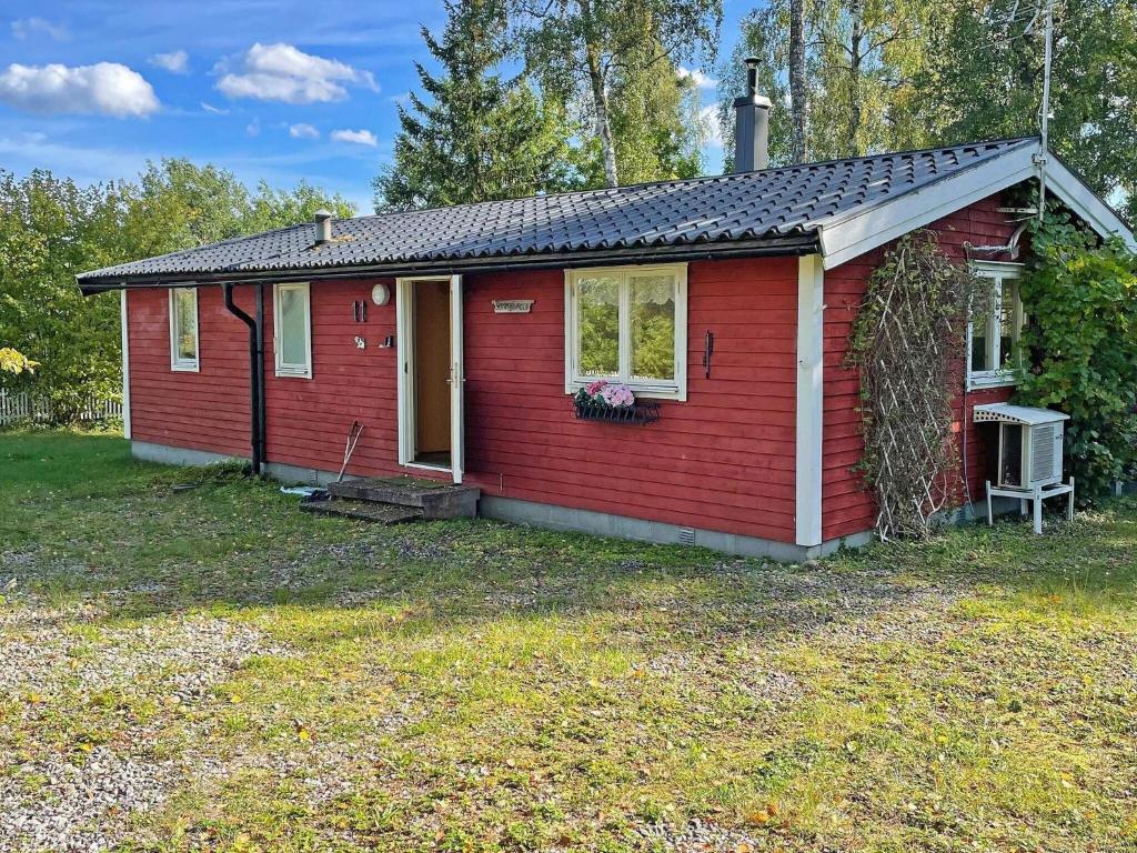 une petite maison rouge avec une terrasse couverte dans l'établissement Holiday home Vingåker III, à Vingåker