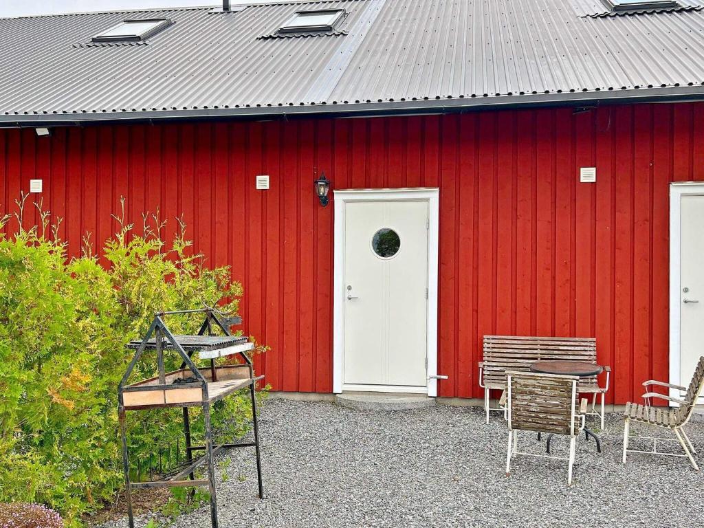 un granero rojo con una mesa y sillas delante en Holiday home MUNSö 