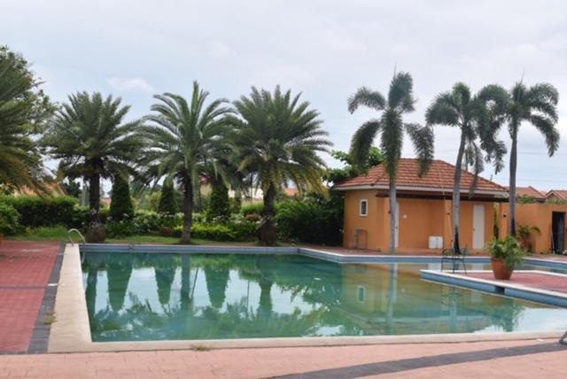 a swimming pool in front of a house with palm trees at SMyleINN camella Jade in Mexico