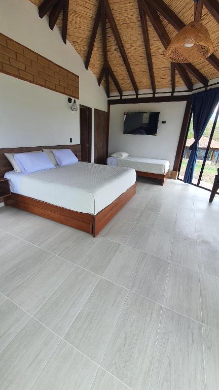 a bedroom with two beds and a wooden ceiling at Cabañas Villa Celeste in Villa de Leyva