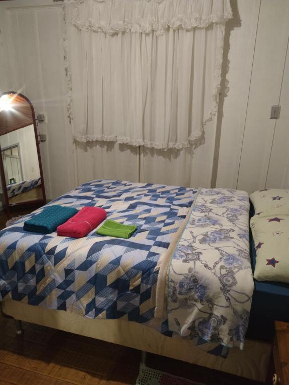 a bed with pillows on it in a bedroom at Casa de madeira em local tranquilo in Mafra