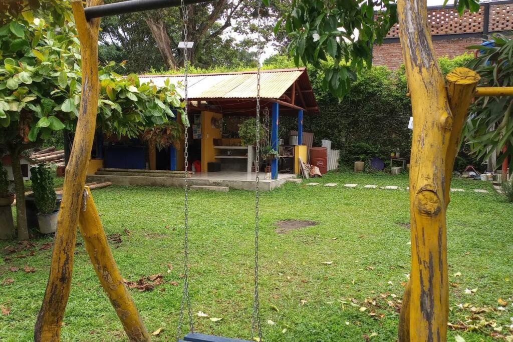 a swing in a yard with a house in the background at La Ramada Campestre in Calarcá