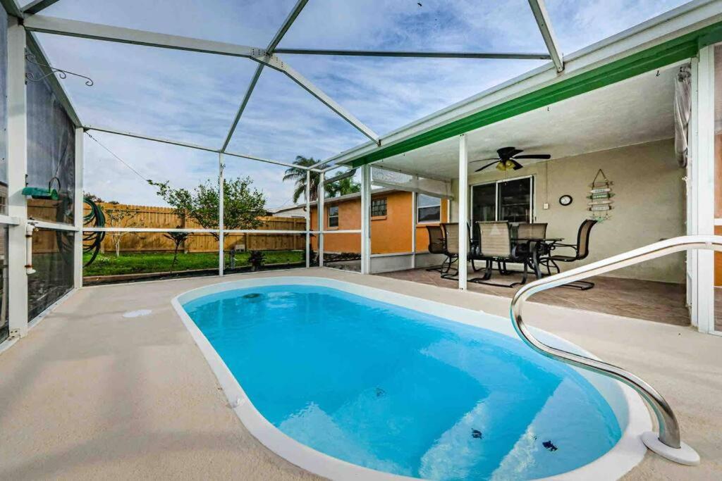 een buitenzwembad met een pergola bij Pool House Close to The Beaches! in Holiday