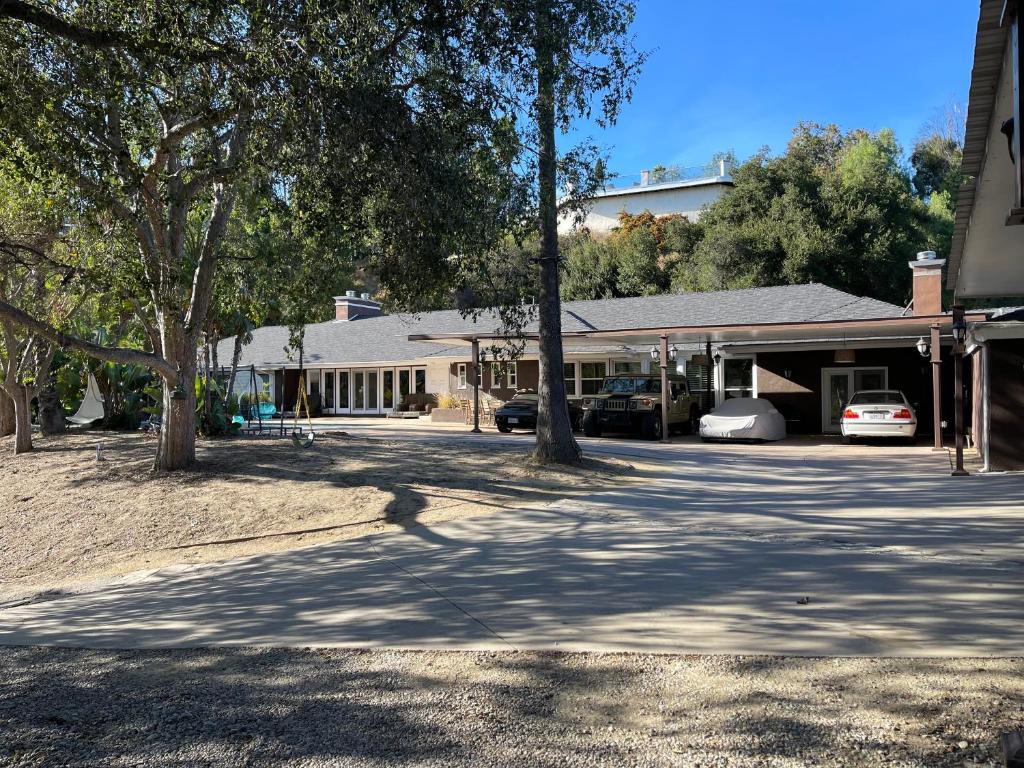 a house with cars parked in front of a driveway at VIEW PRIVATE FEMALE Short-Long Term Day-Week-Month Un-Furnished Home-House-Estate Bedrooms-Studio-ADU-Guesthouse-Vacation Rental Encino Hills 405-101 xSepulveda in Encino
