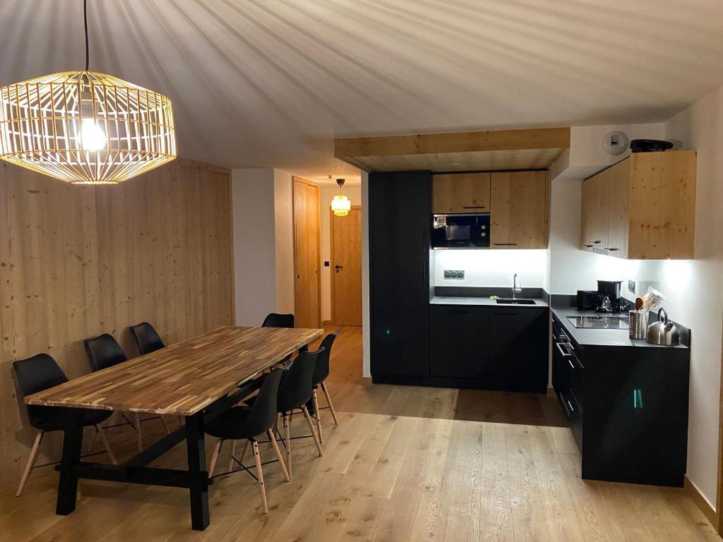 a dining room and kitchen with a wooden table and chairs at Appartement charmant au pied des pistes avec balcon et parking - FR-1-692-93 in La Chapelle-dʼAbondance