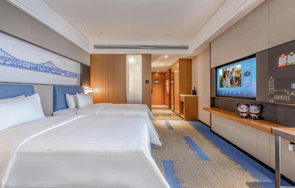 Postel nebo postele na pokoji v ubytování Hampton by Hilton Dongguan Central Plaza