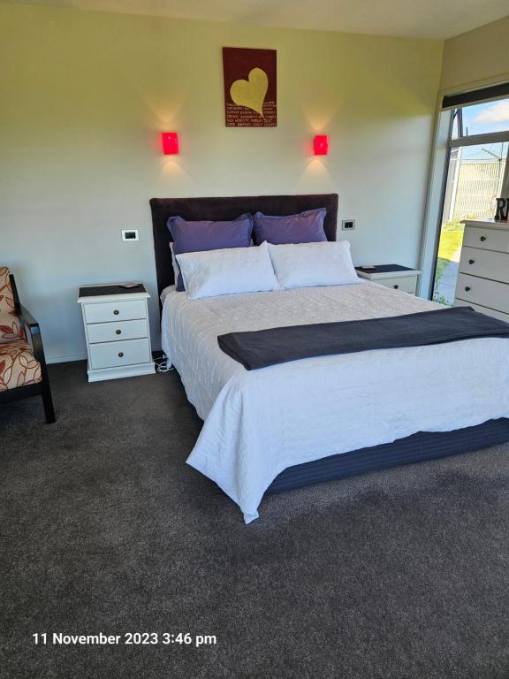 a bedroom with a large bed and a window at House on the Hill in New Plymouth