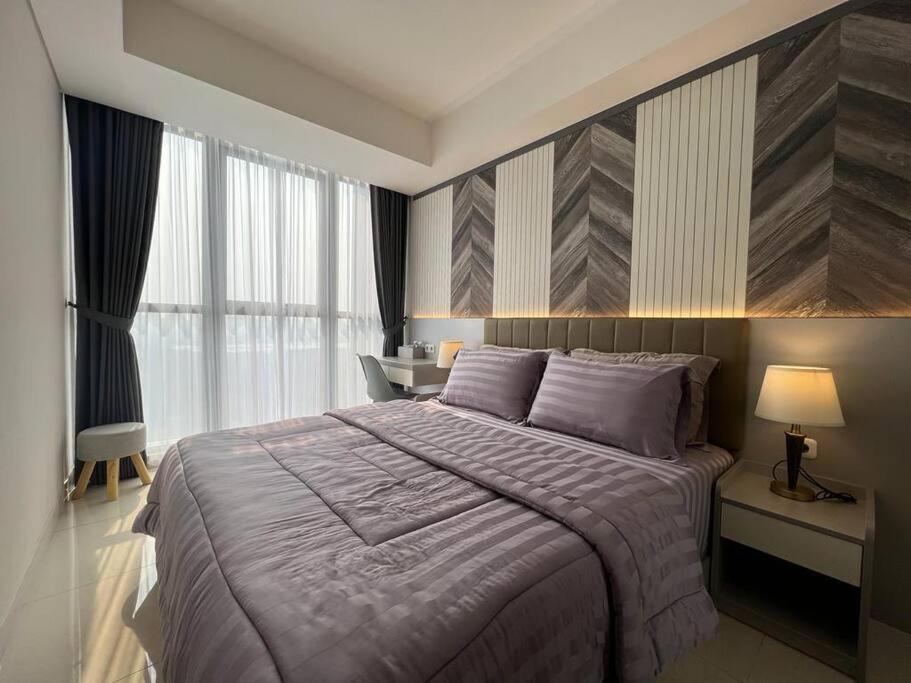 1 dormitorio con 1 cama grande y escritorio en Elegant Mangrove Haven Luxe 1BR at Gold Coast PIK, en Yakarta