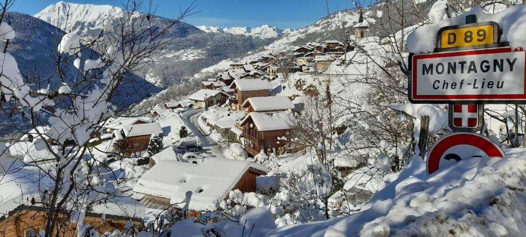 Ski Chalet - Chez Helene Ski fb في Montagny: علامة في الثلج امام جبل