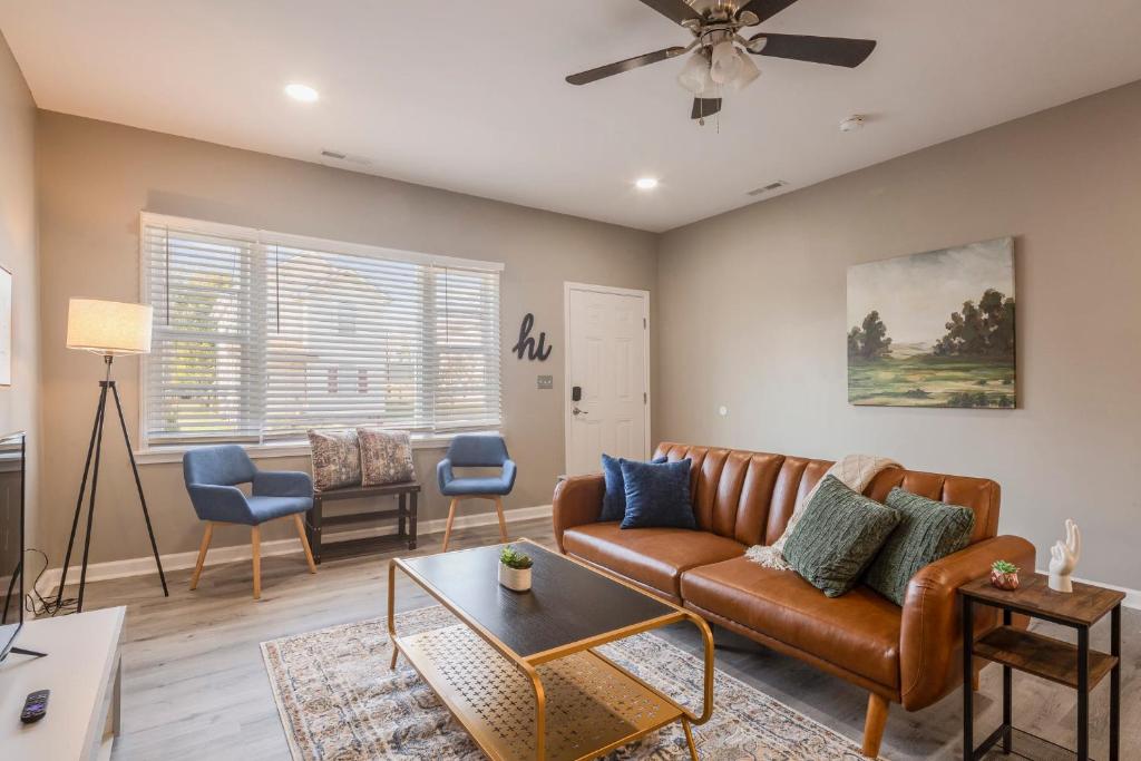 uma sala de estar com um sofá e uma mesa em Newly renovated 4BR CozySuites em Louisville