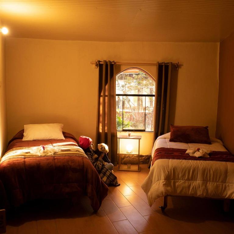 um quarto com 2 camas e uma janela em Valle Andino Lodge em Urubamba