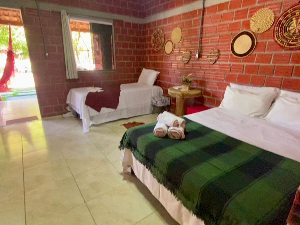 a bedroom with a bed and a brick wall at POUSADA ALLES in Santo Amaro