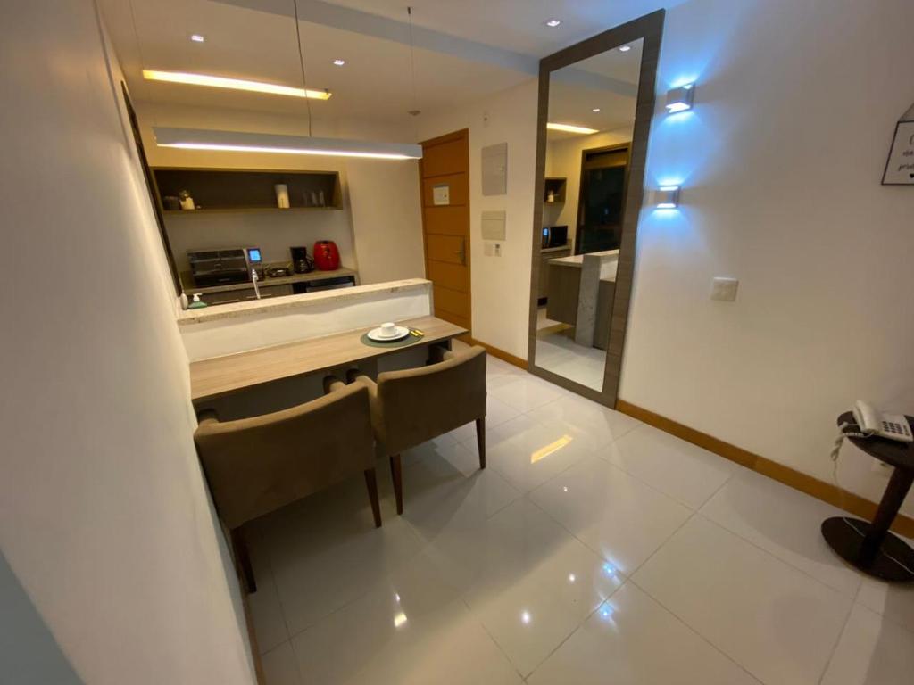 a kitchen with a table and chairs and a mirror at Apart Rio Centro in Rio de Janeiro