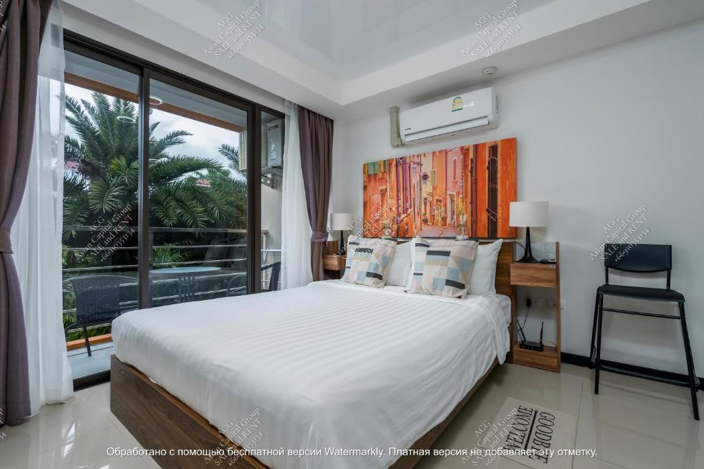 a bedroom with a bed and a large window at Modern MBC condo near the beach in Ban Bo Sai Klang