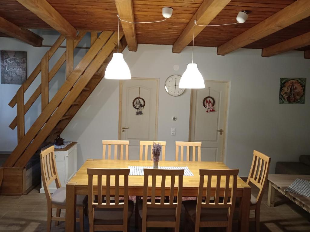 Török Kulcsosház في بايلي هومورود: غرفة طعام مع طاولة وكراسي خشبية