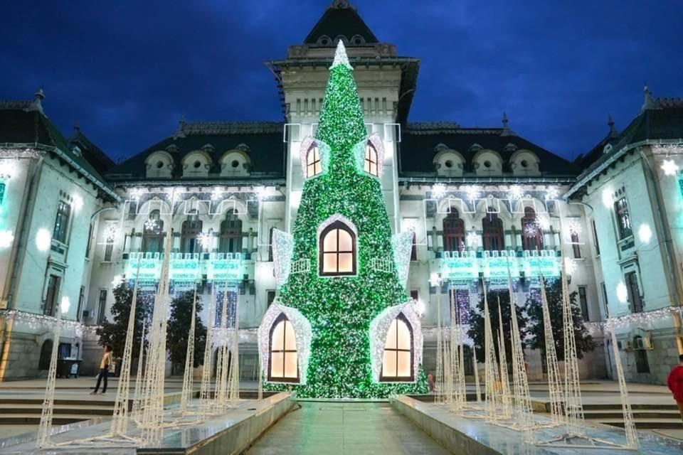 a building with a christmas tree in front of it at Sweet Homme in Craiova