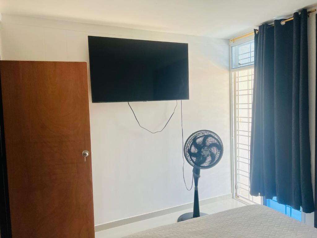 a bedroom with a fan and a television on a wall at Habitación confortable in Valledupar