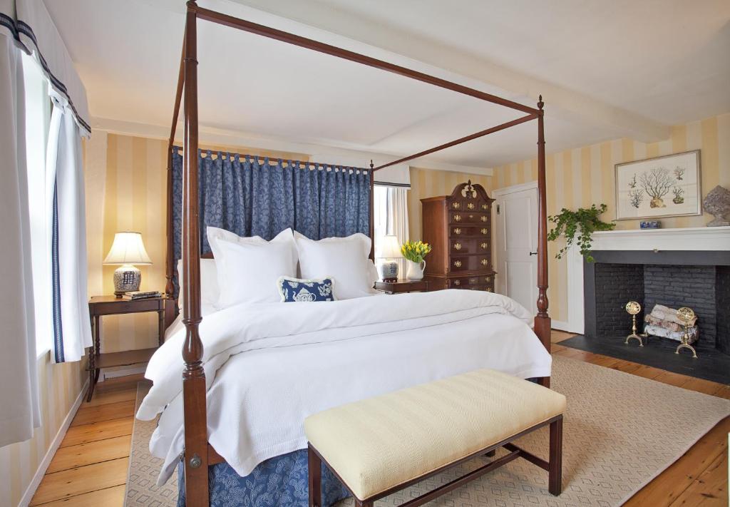 um quarto com uma cama grande e uma lareira em Union Street Inn em Nantucket