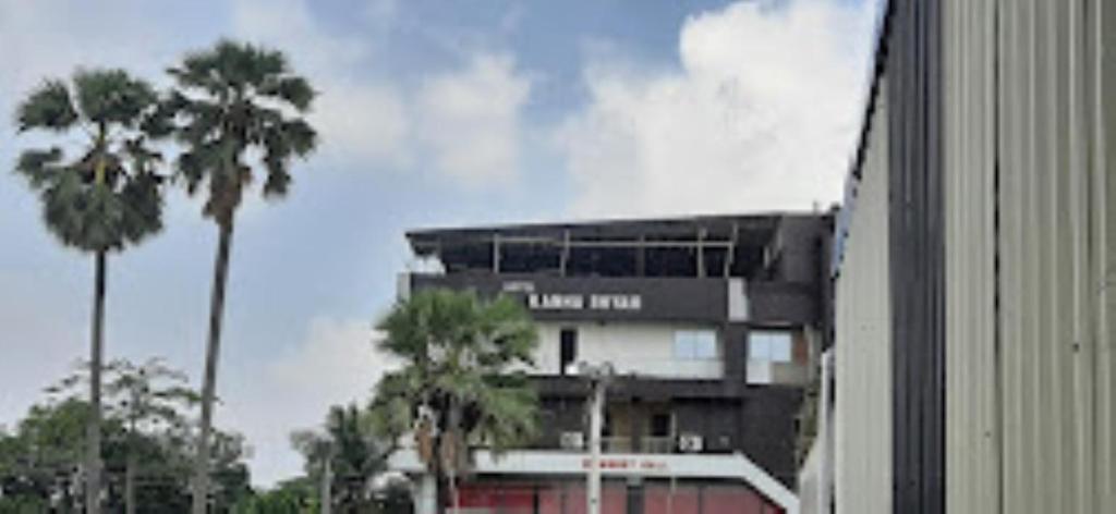 un bâtiment avec des palmiers en face de celui-ci dans l'établissement Hotel Kanha Shyam Madhubani, à Madhubani