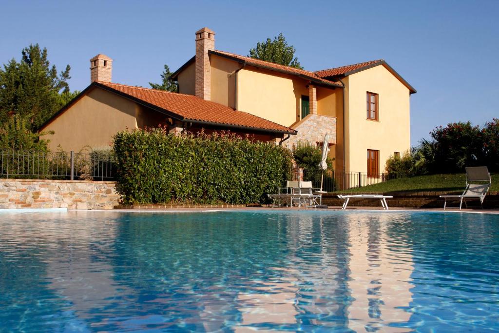 a house and a swimming pool in front of a house at Villaggio Turistico Airone in Riotorto