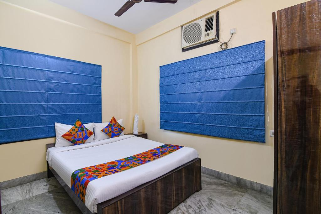 1 dormitorio con 1 cama con pared azul en FabHotel Sapphire Comfort en Calcuta