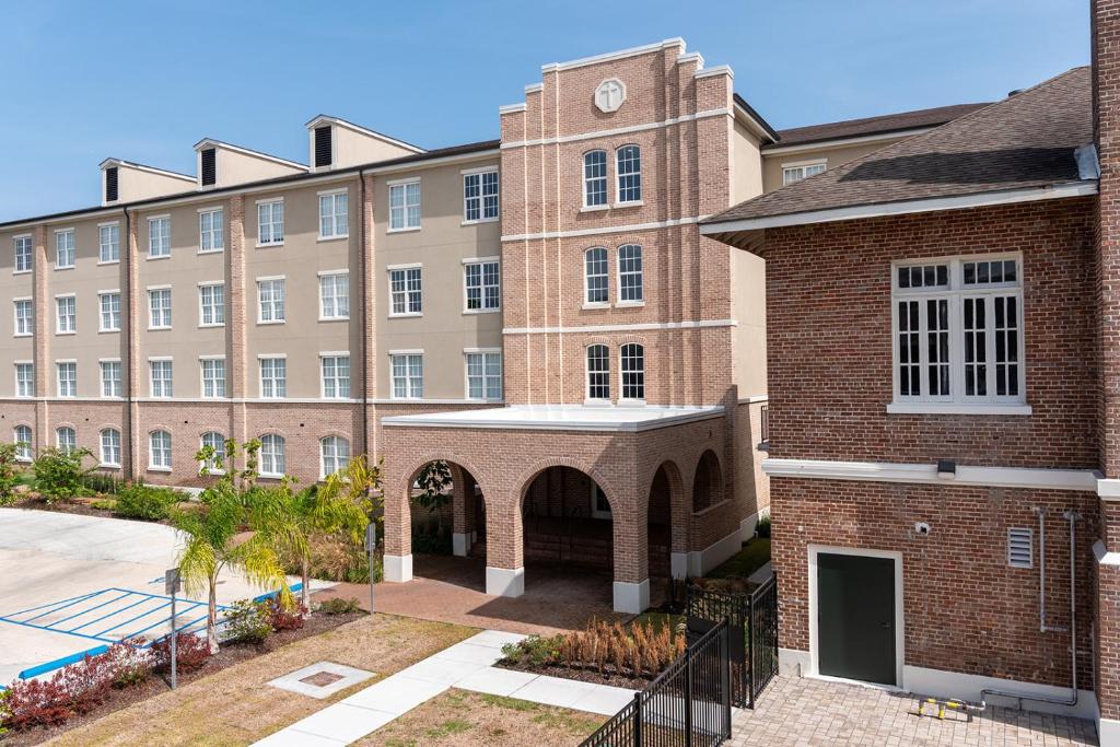 a large brick building with a clock tower at Holy Angels Bywater Hotel and Residences in New Orleans