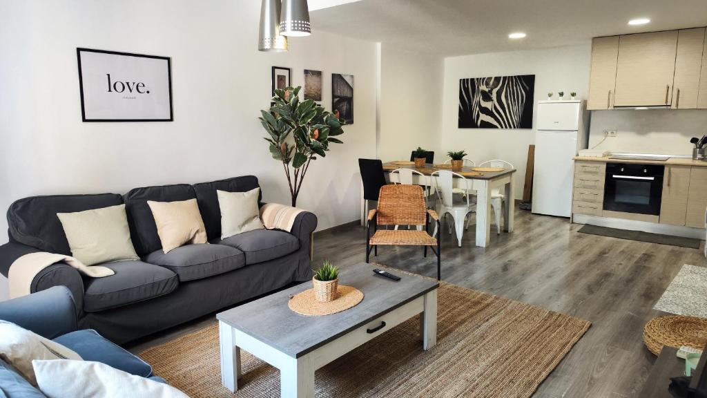 ein Wohnzimmer mit einem Sofa und einem Tisch in der Unterkunft Boutique 2 apartamento Ave centro Lleida in Lleida