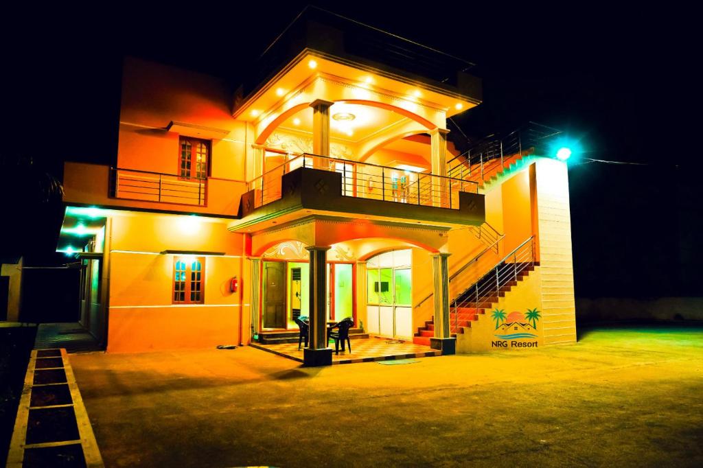 a house with a balcony and a staircase on it at night at NRG Resort in Yelagiri