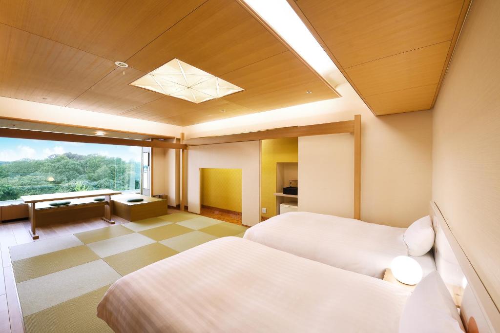 所沢市にある掬水亭のベッド2台と窓が備わるホテルルームです。