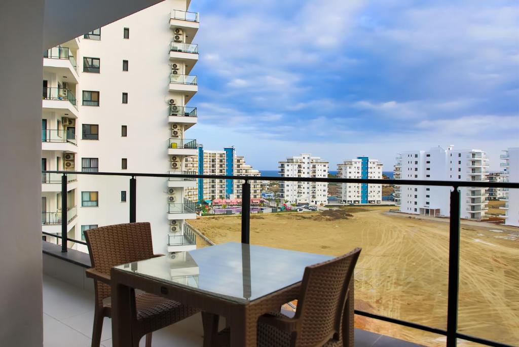 a balcony with a table and chairs and a building at Amadeus Holiday Apartments in Caesar Resort & SPA, Long Beach in Perivolia tou Trikomou