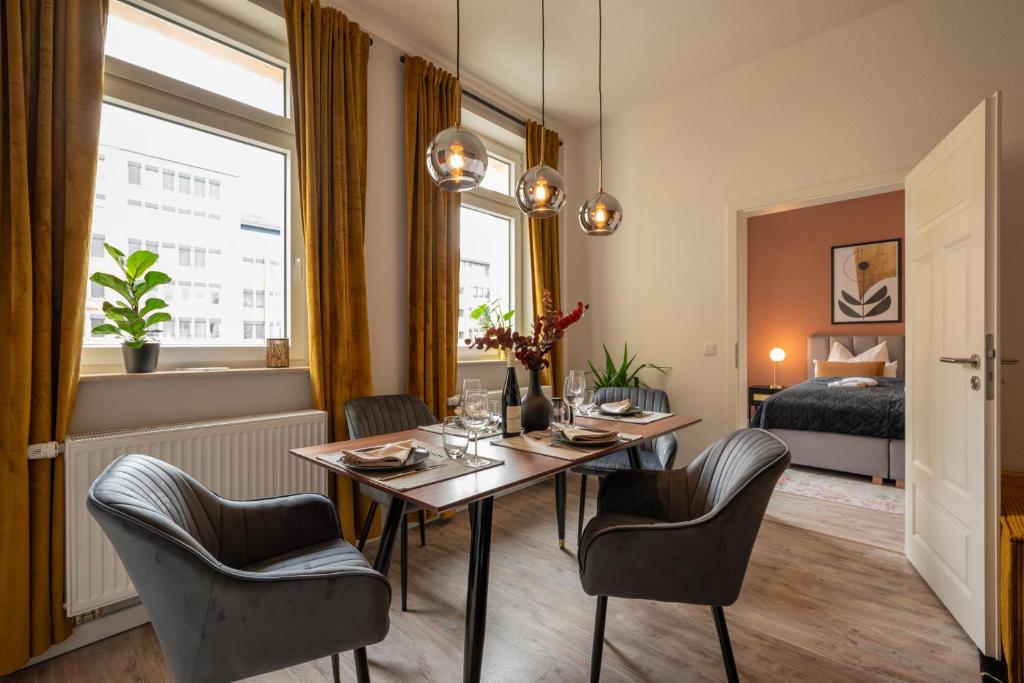 een eetkamer met een tafel en stoelen en een slaapkamer bij maremar - Design Apartment - Luxus Boxspringbett - Zentral - Arbeitsplatz - Highspeed WLAN in Gera