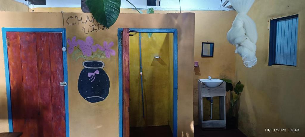 a room with two doors and a sink with a vase on the wall at Hostel La Gloria in Ometepe