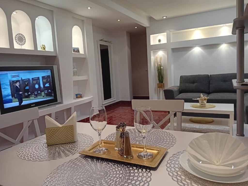 - un salon avec une table et deux verres à vin dans l'établissement PERLA PREMIUM APARTMENT, à Timişoara