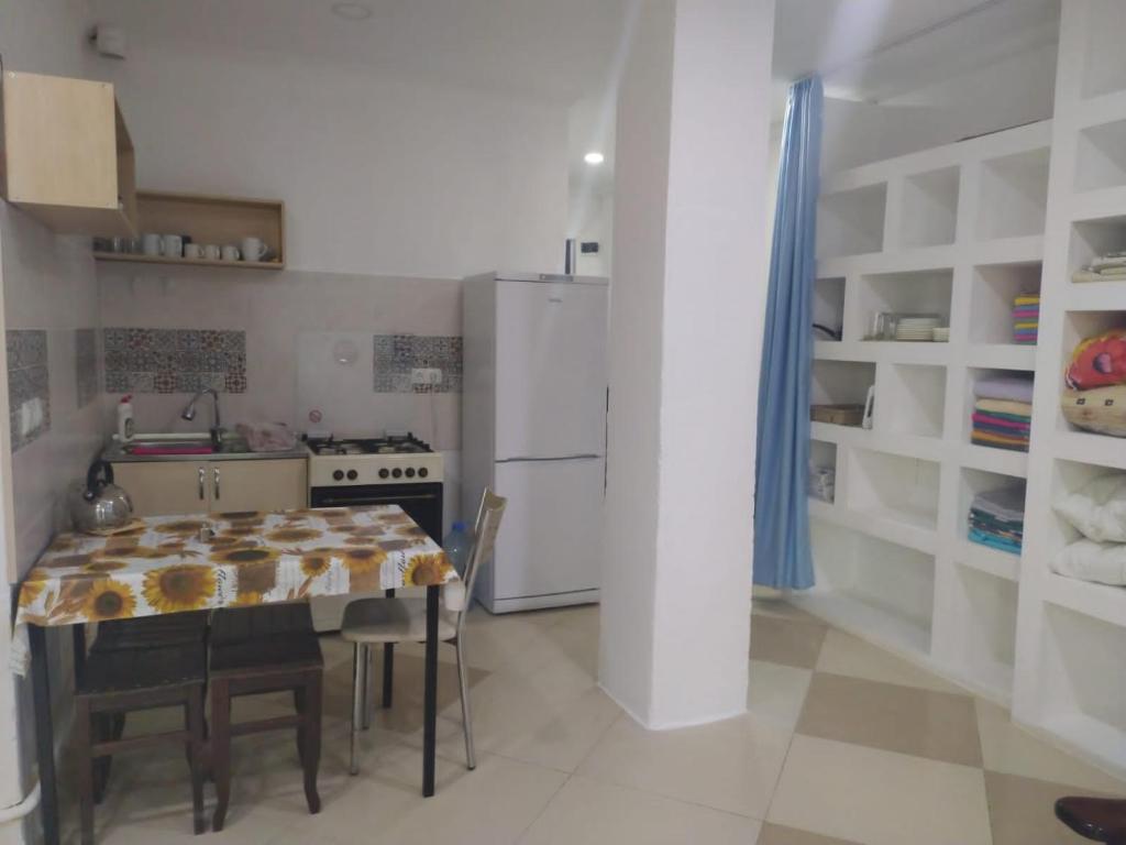 a kitchen with a table and a refrigerator at Квартира-студия с видом на море in Ureki