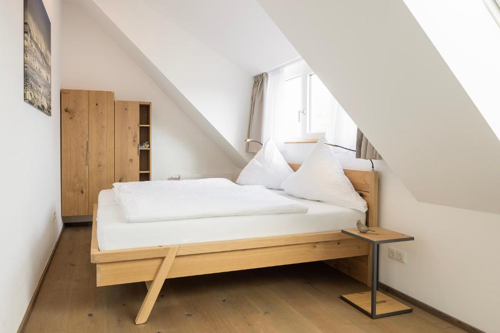 ein Bett in einem kleinen Zimmer mit einer Treppe in der Unterkunft Schwalbennest 1-3 in Juist