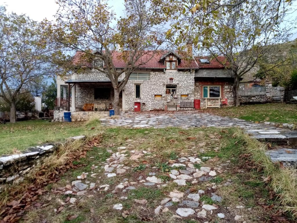 una vieja casa de piedra con un árbol en el patio en Residence "Ana Pletvarska", en Prilep