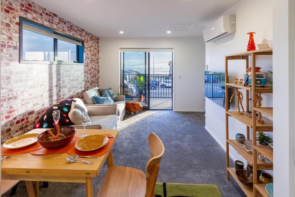 a kitchen and living room with a table and chairs at Okioki - Seaside Escape in Christchurch