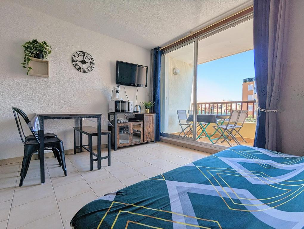 sypialnia ze stołem i widokiem na balkon w obiekcie Appartement au CALME + parking w Cap d'Agde