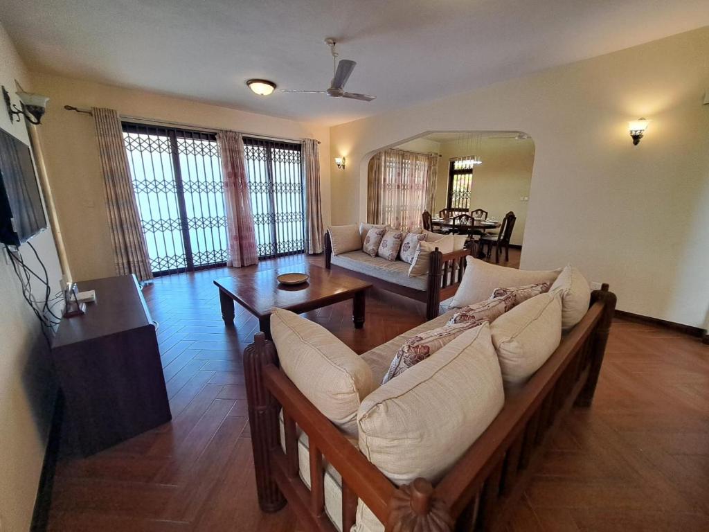 a living room with a couch and a table at Marique villa in Mombasa