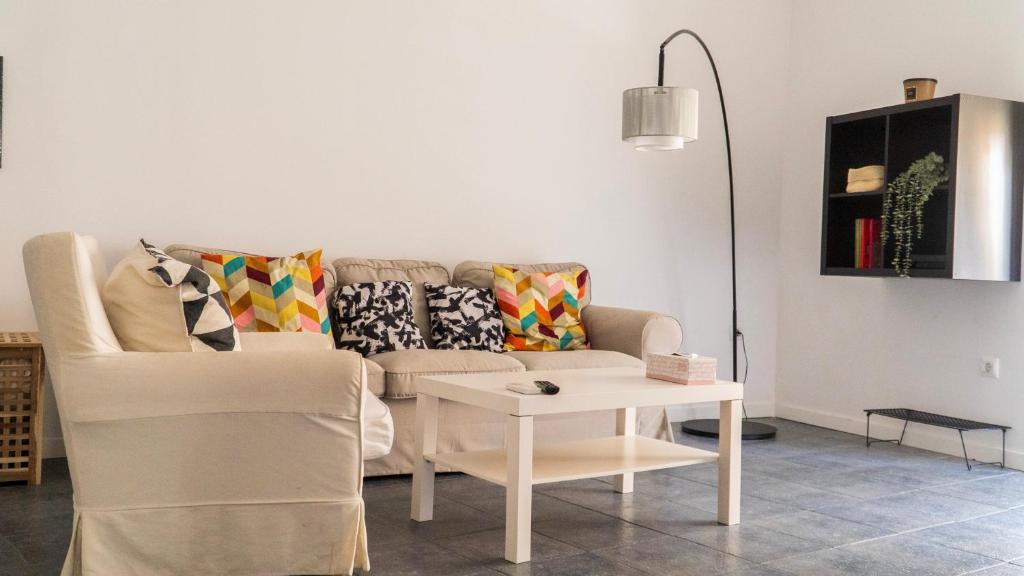 un soggiorno con un divano e un tavolo di Apartamentos Entreteatros, fantástico duplex casco histórico a Talavera de la Reina