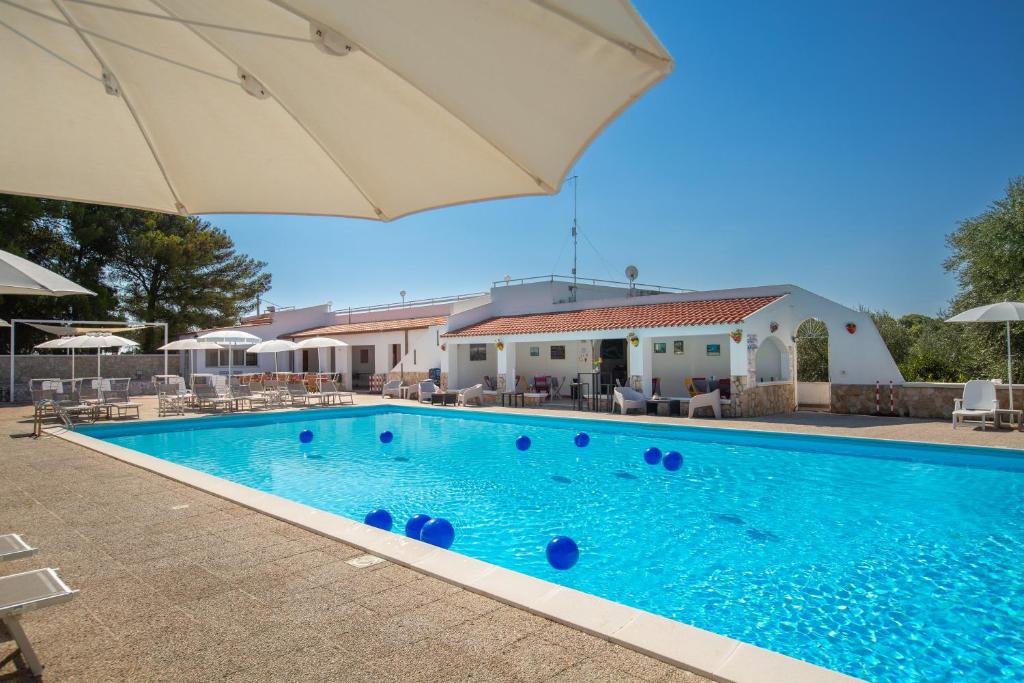 維耶斯泰的住宿－Centro Vacanze Piccolo Friuli，一个带遮阳伞和椅子的游泳池
