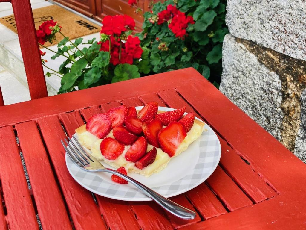 a strawberry pie on a plate on a red table at La Blatière French Cottages in La Chapelle-Saint-Étienne