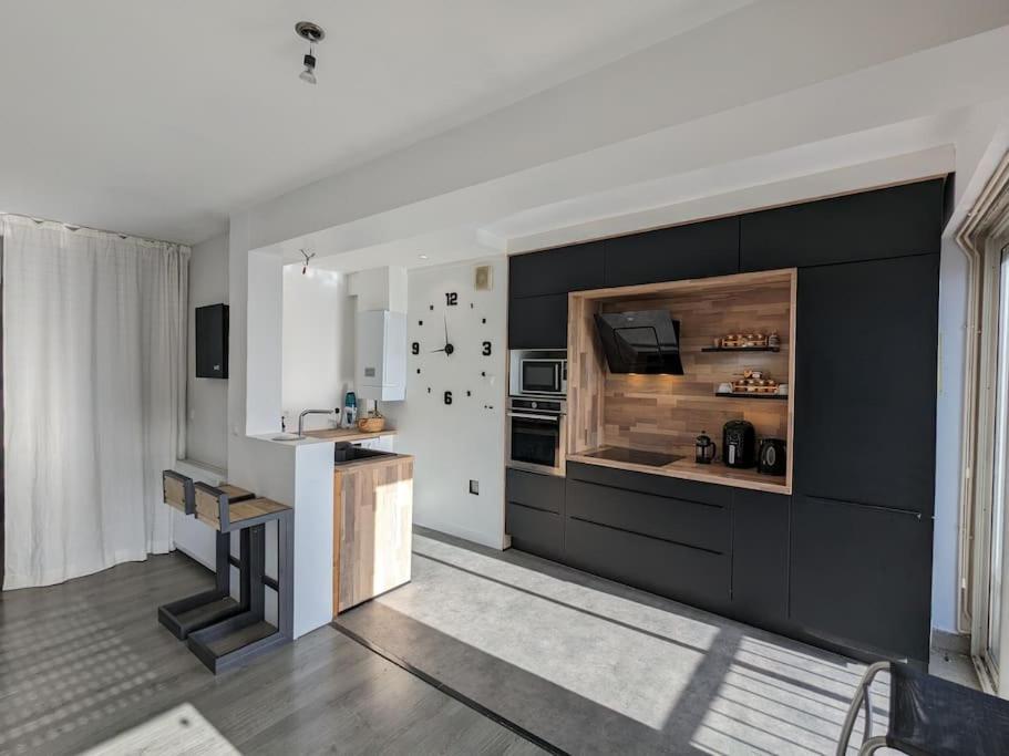 a living room with a kitchen with a large fireplace at Hyper Centre La Roche sur Yon - Appartement spacieux et lumineux in La Roche-sur-Yon