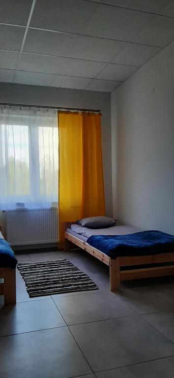 1 dormitorio con 2 camas y cortina amarilla en Air Tel Home en Radom