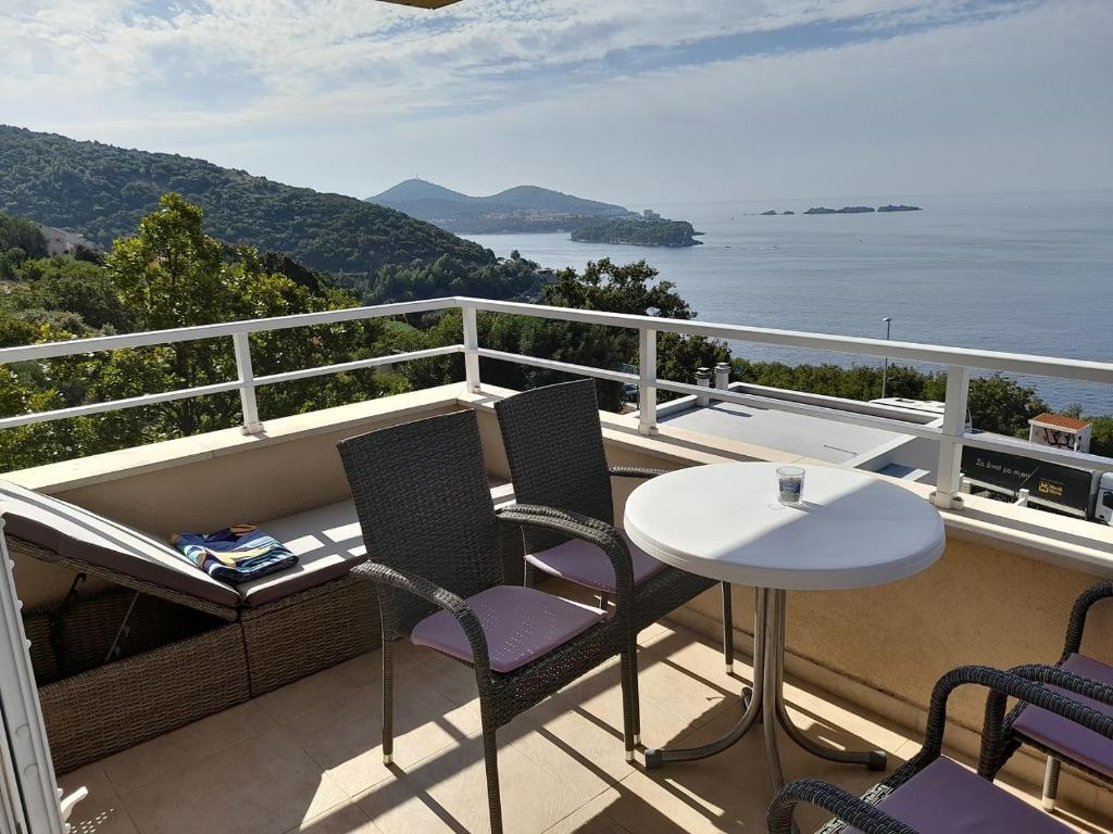 een balkon met een tafel en stoelen en de oceaan bij Apartmani NIKA in Dubrovnik