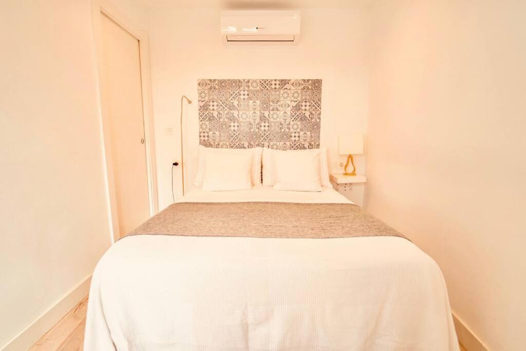 a small bedroom with a white bed in a room at Torre de la Vela 2 in Granada