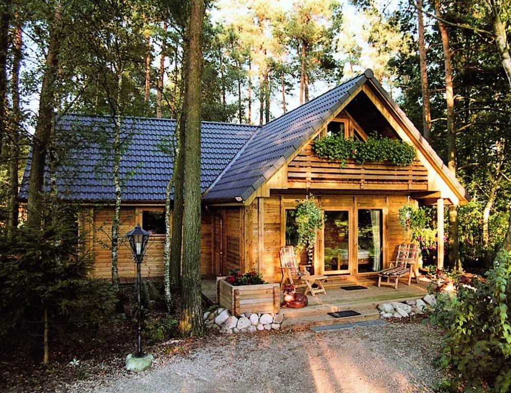 eine Holzhütte im Wald mit einer Veranda in der Unterkunft Ferienpark Leitzingen in Soltau