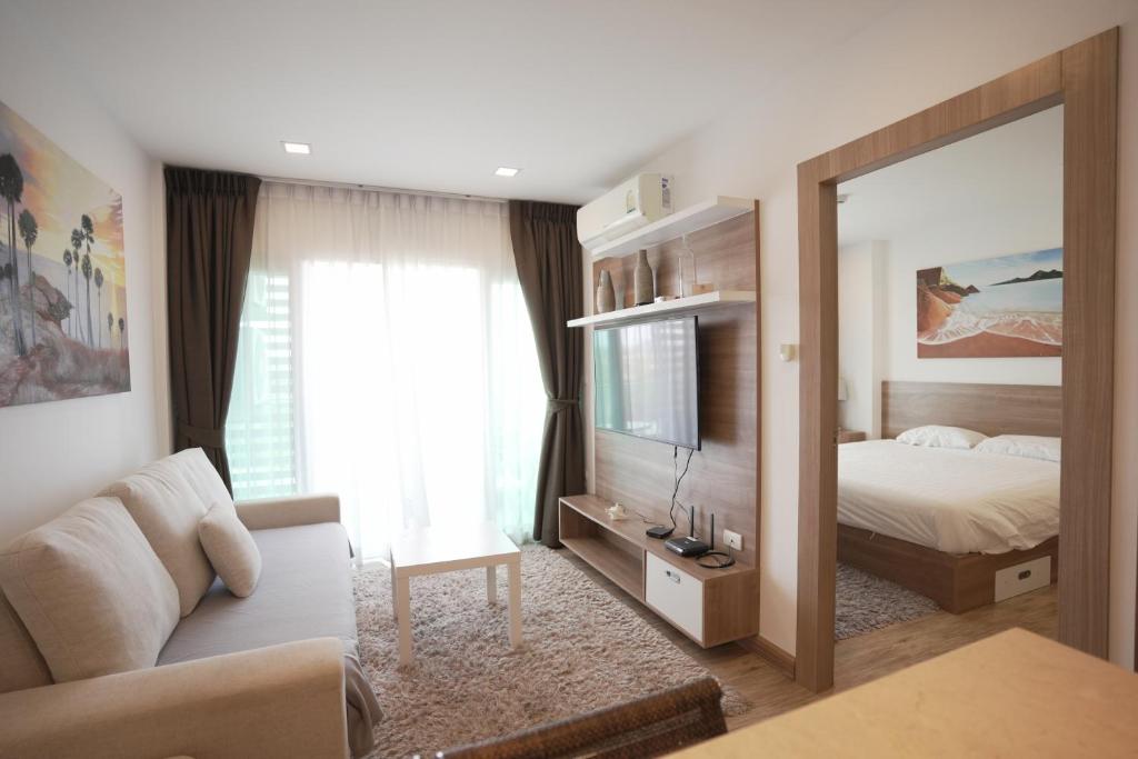 a bedroom with a bed and a large mirror at Calypso Condo Rawai Nai Harn beach in Rawai Beach